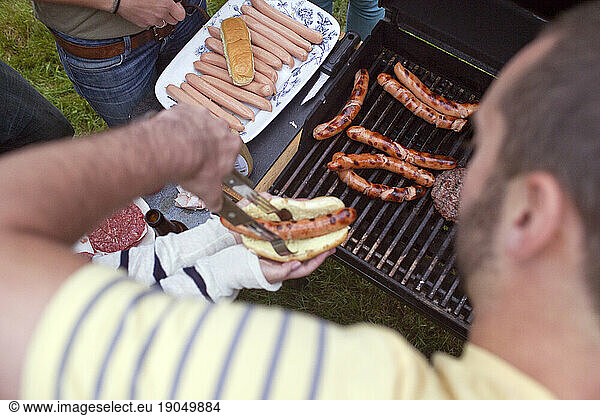 Young man tends grill at a barbecue