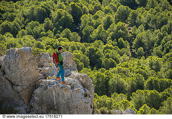 Young man treks through rocky landscape at sunrise  Costa Blanca