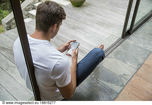 Young man using smart phone at home