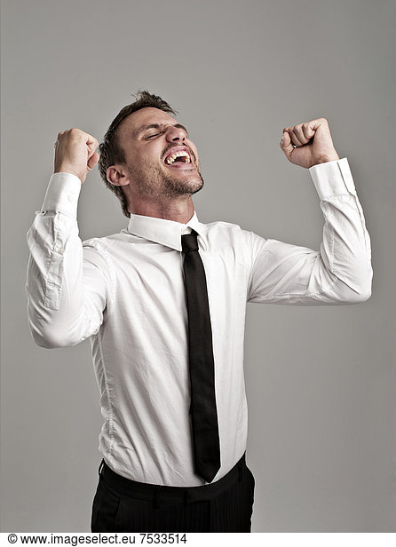 Young man wearing a shirt and a tie cheering  success  victory pose