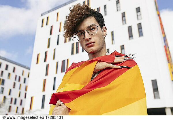 Young man wearing rainbow flag