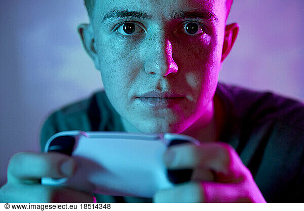 Young man with controller playing video game