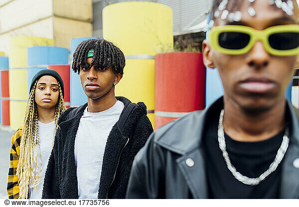 Young man with locs standing by friends
