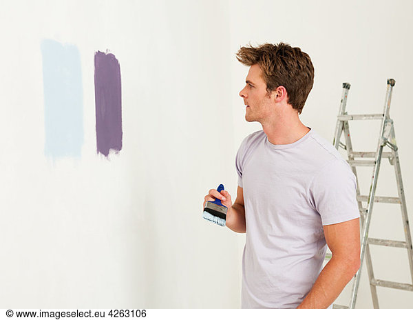 Young man with paint on wall