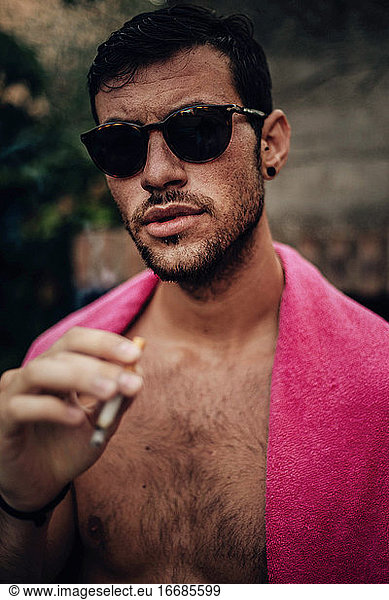 Young man with sunglasses smoking a cigarette