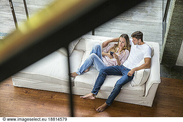 Young man with woman using smart phone at home
