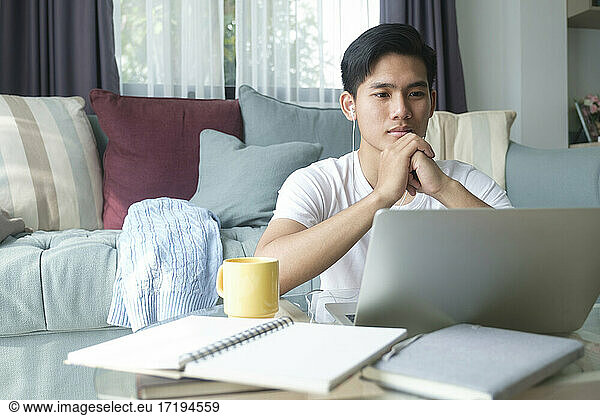 Young man working and learning online at home.