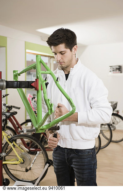 Young man working on bicycle frame