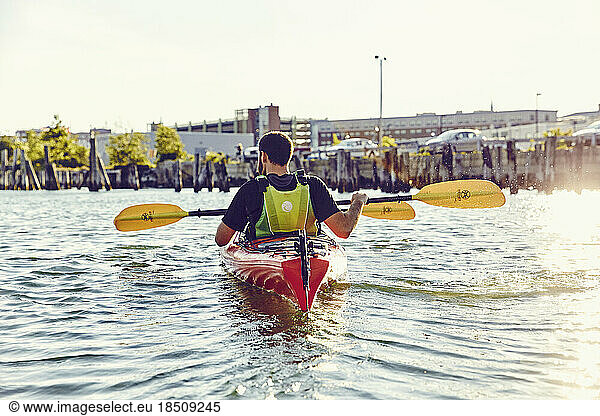 Young men in a tandem kayak at sunset in Casco Bay  Maine