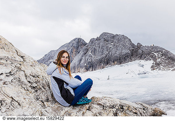 young millennial girl enjoys the views of the Alps standing on glacier
