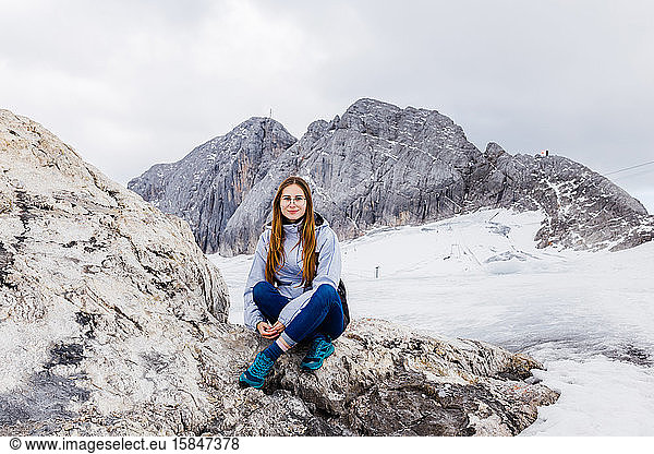young millennial girl enjoys the views of the Alps standing on glacier
