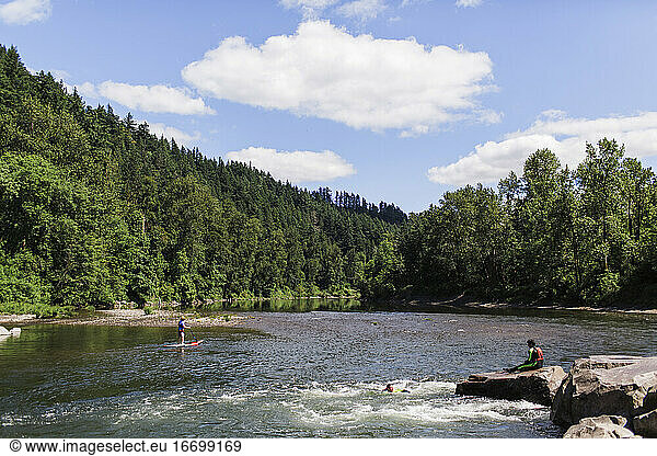 Young people enjoy a calm river during a summer day in Oregon.