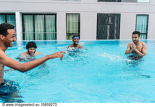 Young people making jokes inside a pool surrounded