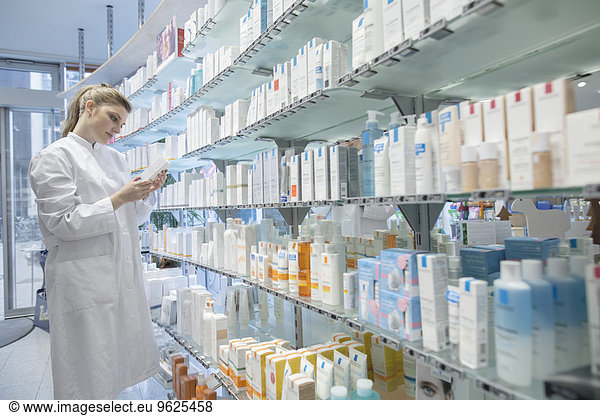 Young pharmacist in pharmacy choosing medication