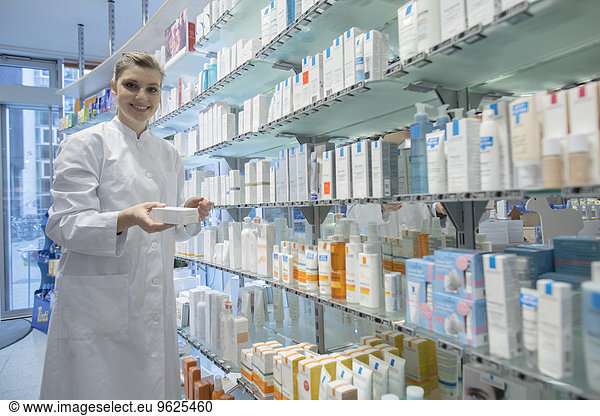 Young pharmacist in pharmacy choosing medication