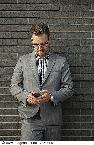 Young professional man projecting confidence while using mobile