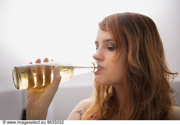 Young Red Haired Woman Drinking Beer From The Bottle Young Red Haired Woman Drinking Beer From