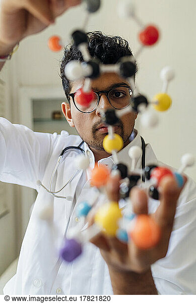Young scientist examining helix model in laboratory