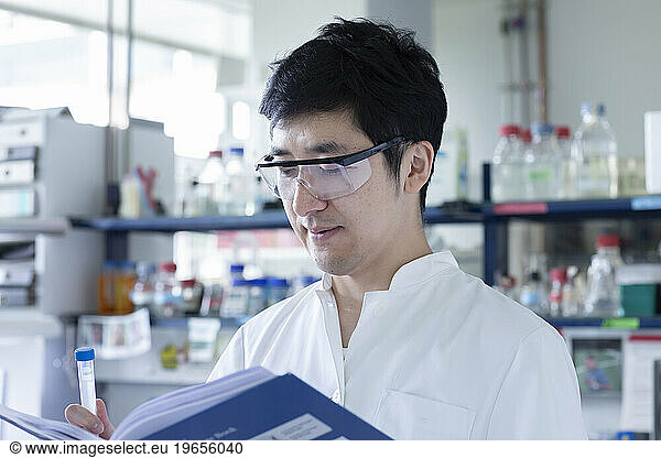 young scientist male chinese working in laboratory