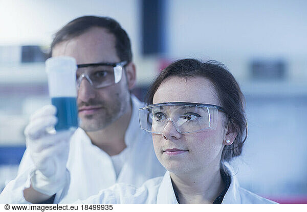 Young scientists examining test tube in a laboratory  Freiburg Im Breisgau  Baden-wuerttemberg  Germany