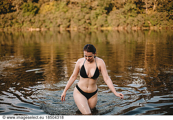 Young seductive woman walking in lake