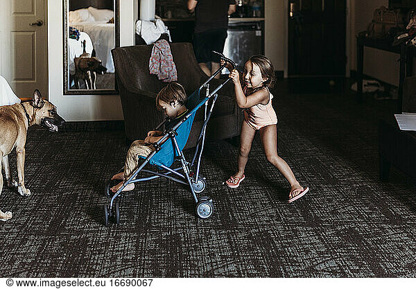 Young siblings playing in stroller in hotel room in Palm Springs