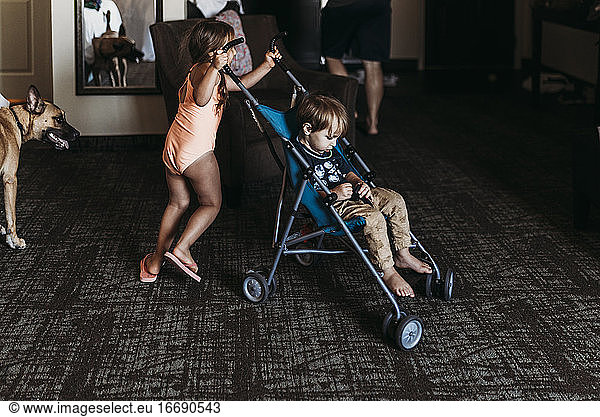 Young siblings playing in stroller in hotel room in Palm Springs