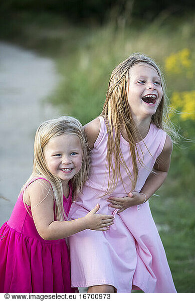 Young Sisters Laughing in Pink Summer Dresses