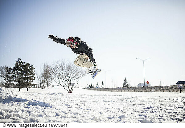 Young snowboarder in mid air doing jump