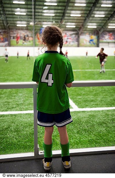 Young soccer player watches an indoor game
