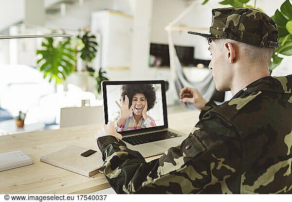 Young soldier man on video call with girlfriend through laptop at home