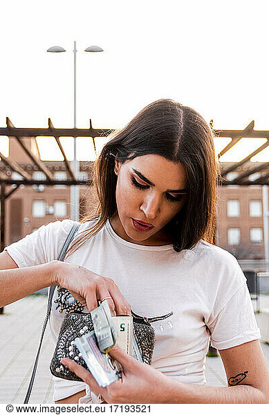 Young Spanish brunette woman counting her money.