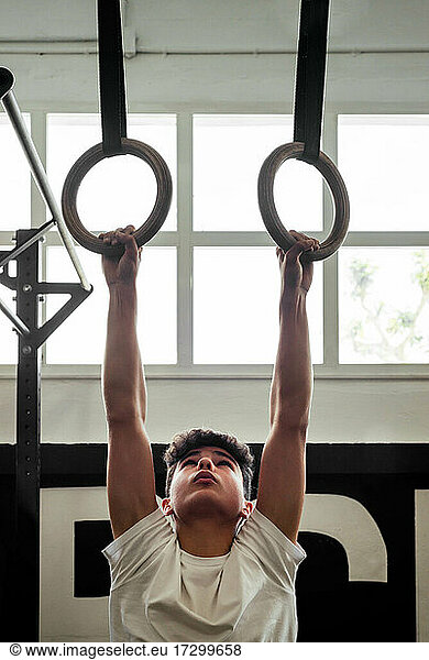 Young Sportsman Holding Rings In A Crossfit Box
