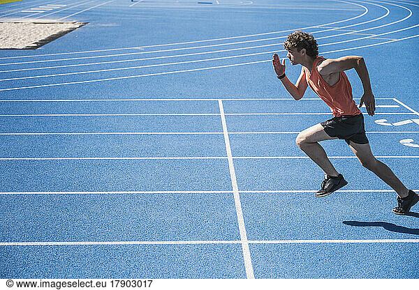 Young sportsman running on track