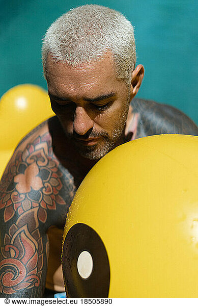 Young stylish tattooed spanish man in the pool.