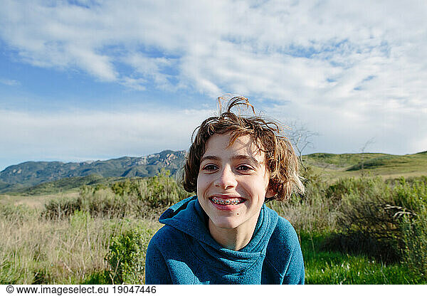 Young teen girl with braces smiles while outside in nature