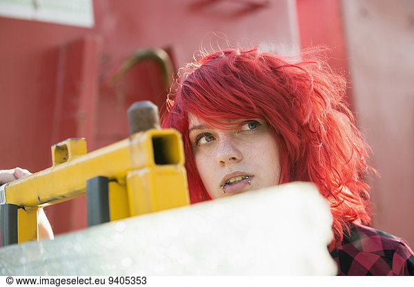Young teenage girl dyed red hair piercings
