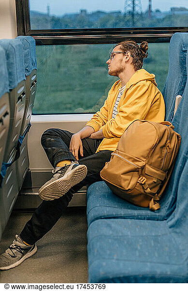 Young teenage man travels in train  public transport.