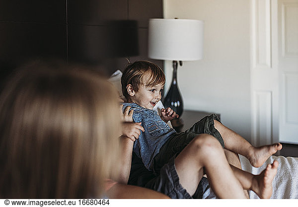 Young toddler boy laughing on hotel bed on vacation in Palm Springs