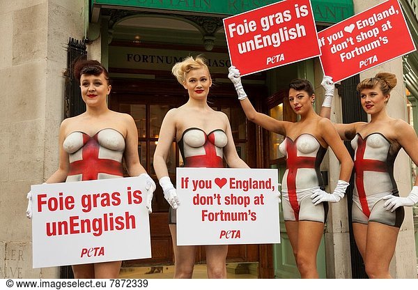 Young topless girls wearing Union Jack body-paint protest against animal cruelty outside Fortnum And Masons luxury goods store Jermyn Street London England