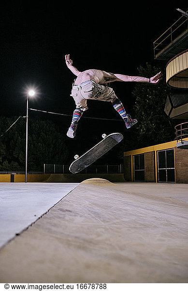 young white man jumping on his skateboard