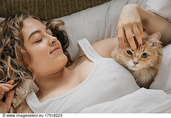 Young woman and ginger cat in trailer close-up.