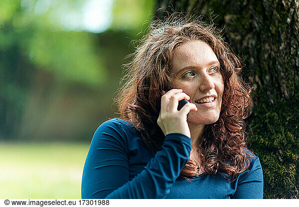 Young woman at listening to smartphone outdoors