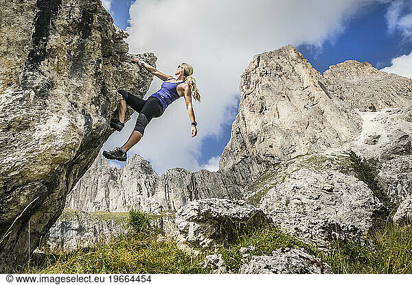 Young Woman Bouldering In The Dolomites Near Rosengarten
