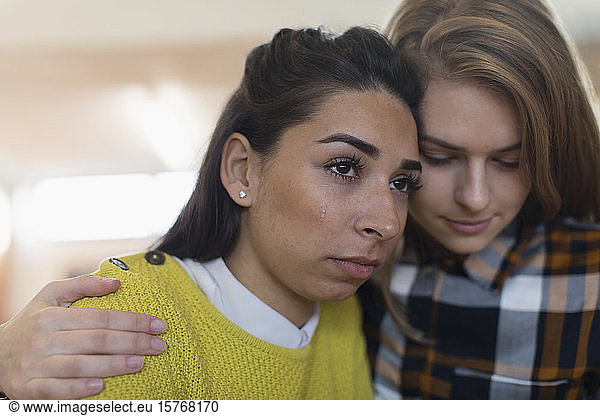 Young woman consoling crying friend