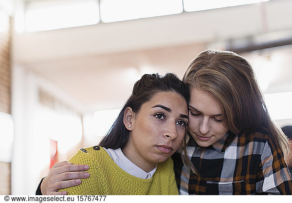 Young woman consoling friend