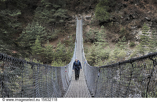 Young woman crossing Phakding suspensio bridge  Solo Khumbu  Nepal