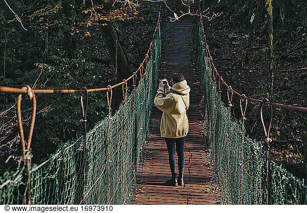 Young woman crossing suspension bridge