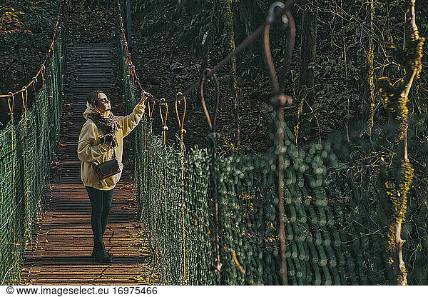 Young woman crossing suspension bridge