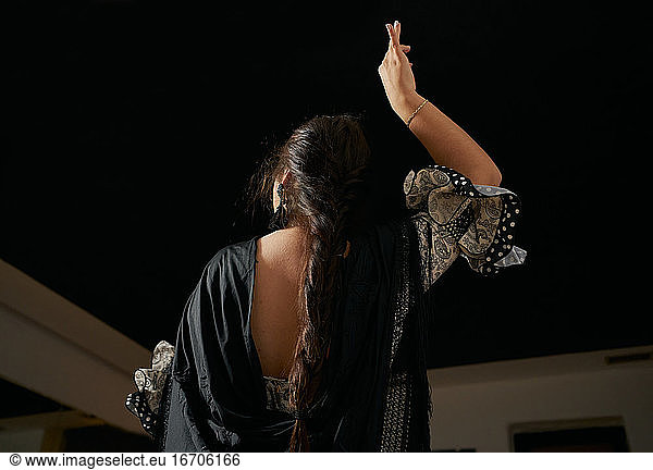 Young Woman Dancing Flamenco On Black